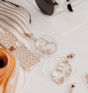 Gold-colored earrings with a face shape